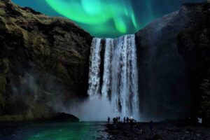 The Northern Lights over Skogafoss waterfall in Iceland