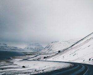 A winding road through the snowy mountains in Iceland during winter