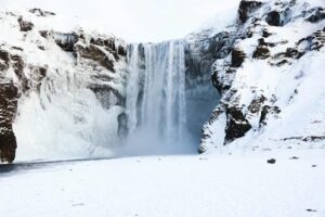 Skogafoss waterfall covered in ice and snow in Iceland during winter