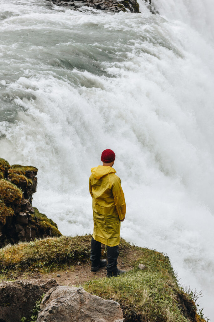 Rear view of man standing near Gullfoss waterfall in Iceland