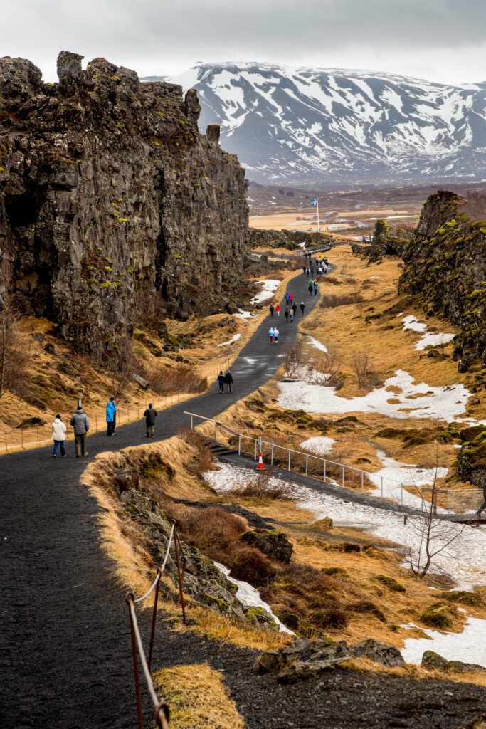 Tourists walking at the Thingvellir national park in Iceland in spring.
