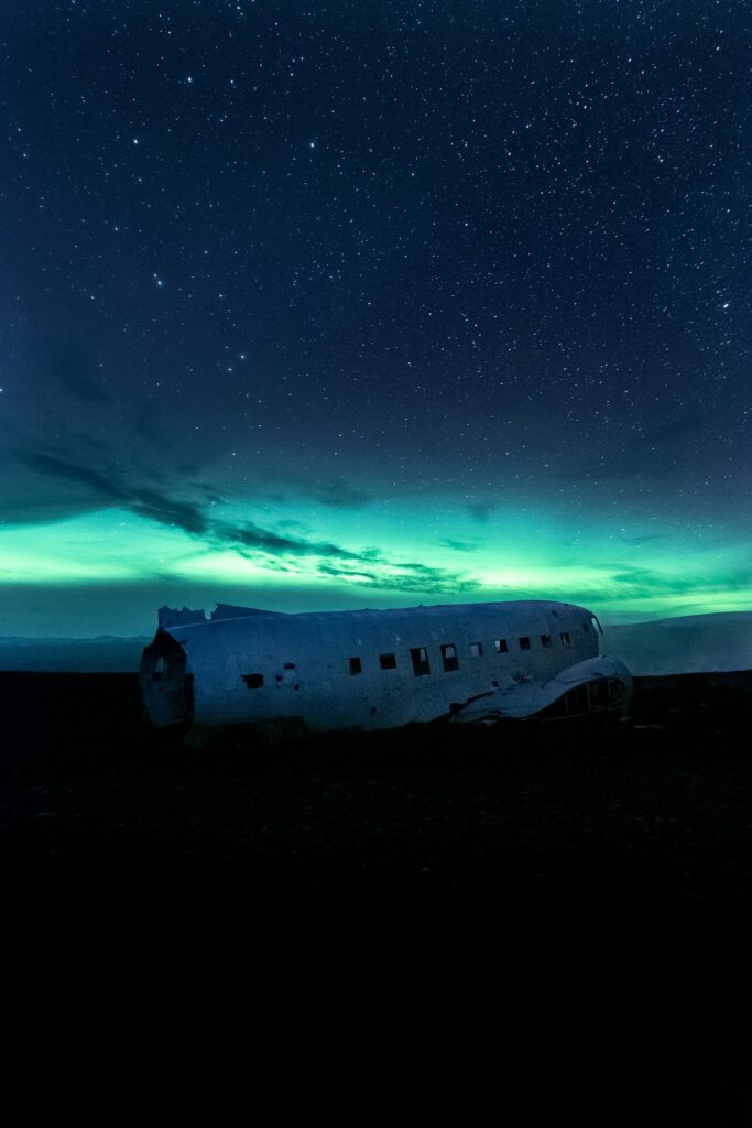 The Northern Lights by the plane wreck in Iceland