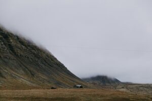 A house sitting at the side of a fjord in Iceland's westfjords region during summer