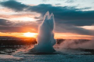 Strokkur geysir erupting in Iceland's Golden Circle under the midnight sun
