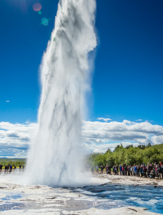Strokkur geyser in Iceland erupting in front of a crowd of people