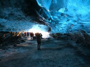 A family group exploring a natural blue ice cave in Iceland