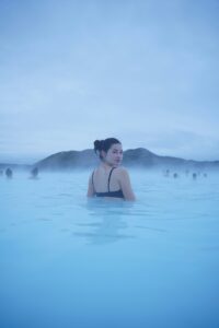 A girl relaxing in the blue waters of the Blue Lagoon in Iceland