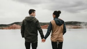 A couple holding hands surrounded by geothermal pools in Iceland