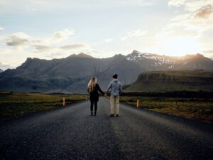 A couple holding hands on the ring road on a romantic trip to Iceland