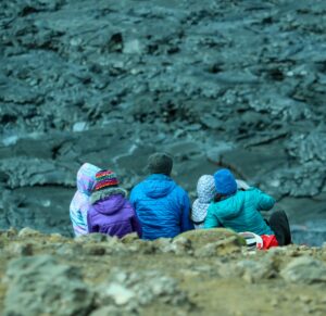 A family watching an erupting volcano during a vacation to Iceland