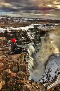 A man meditating in Iceland by Gullfoss Waterfall in the Golden Circle