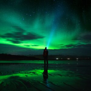 A person staring up at the northern lights in Iceland