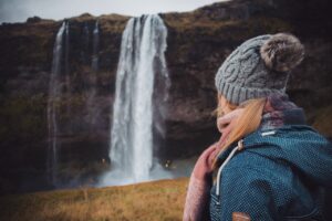 A tourist visiting Seljalandsfoss in Iceland in August