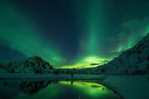 A man standing beneath the Northern Lights in Iceland