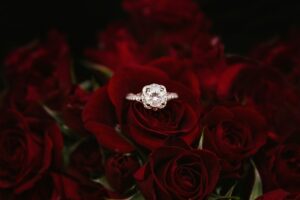 An engagement ring sitting in a load of rose petals