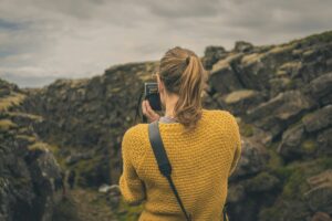 A relaxed Icelandic girl taking a picture of the nature