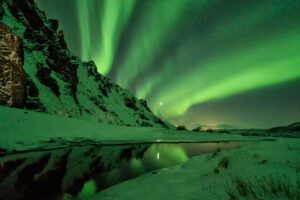 The Northern Lights in Iceland over a snow-covered mountain