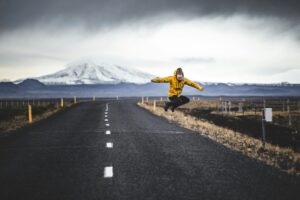 A man jumping in the air in Iceland near a glacier