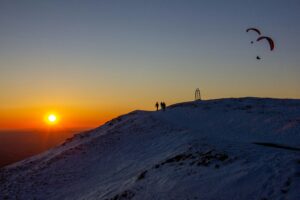 People watching the midnight sun in Iceland from the top of a mountain