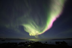 Beautiful pink and green Northern Lights under an August sky in Iceland